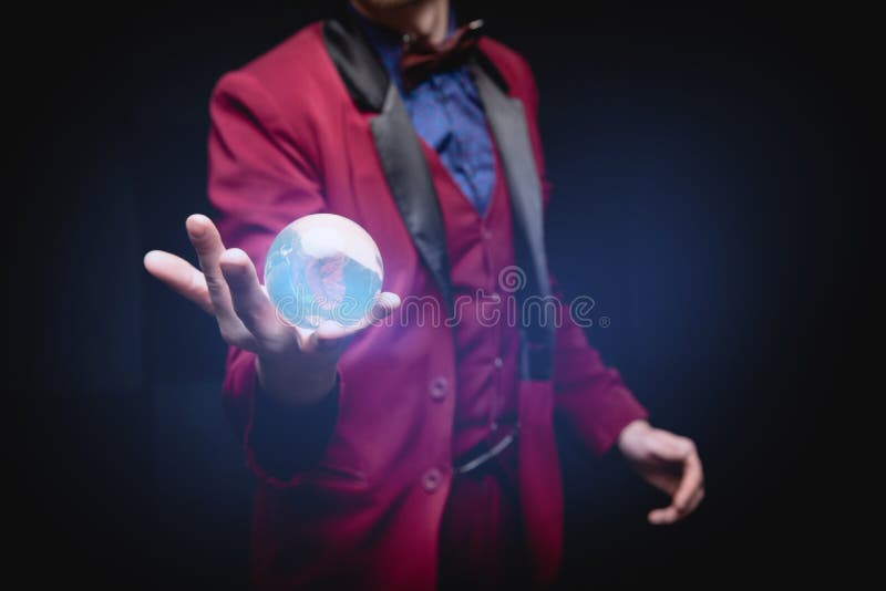 Oracle mostra il futuro nelle mani della sfera con un bagliore magico sullo sfondo nero
