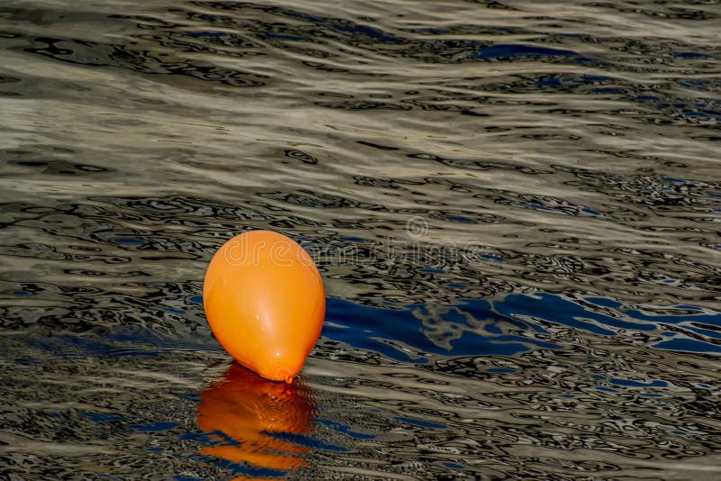 Orange Balloon in the Water of the River. Stock Photo Image of
