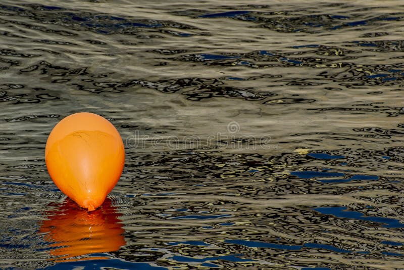 Orange Balloon in the Water of the River. Stock Photo Image of
