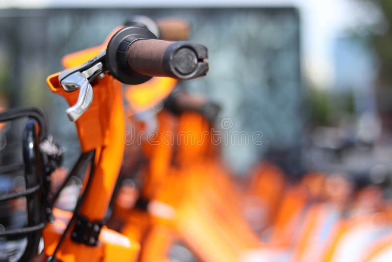 Orange Bike Handle with More Bikes in the Background Stock Photo