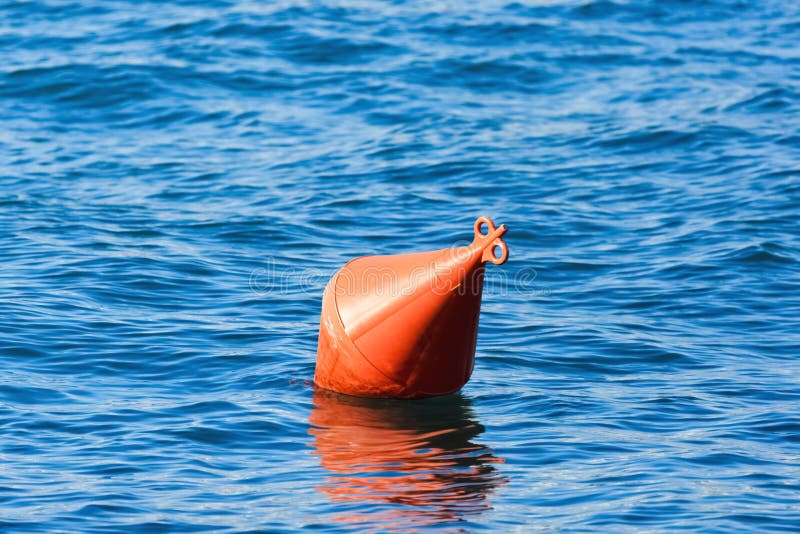 Orange buoy on blue water. Orange buoy on blue water