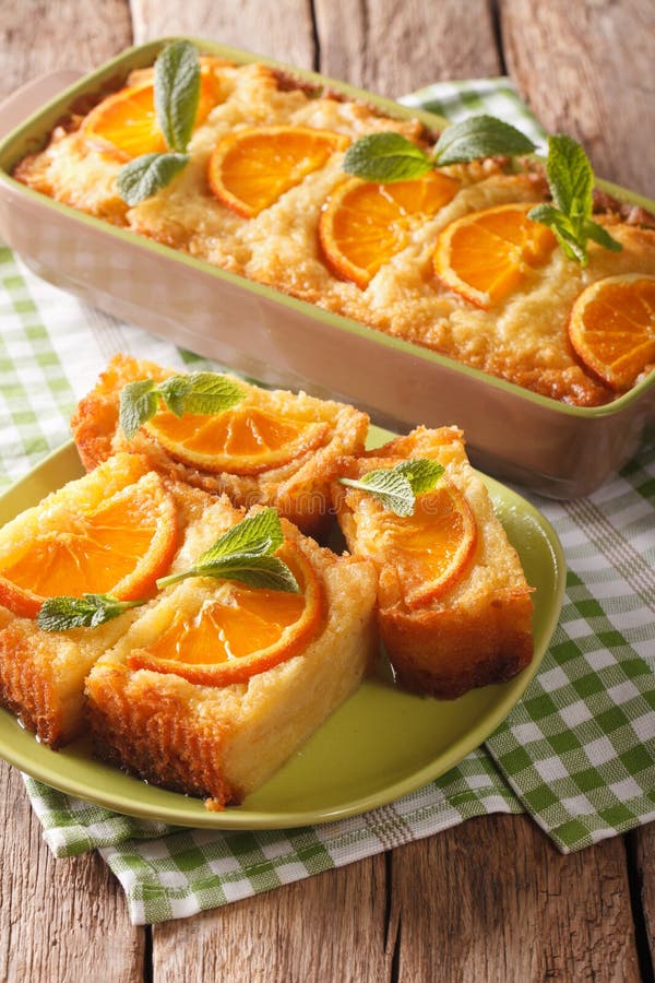 Orange cake soaked in syrup on a plate close-up. vertical