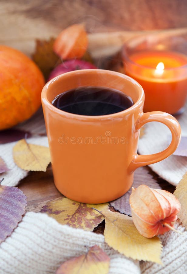 Orange coffee cup on the autumn fall leaves