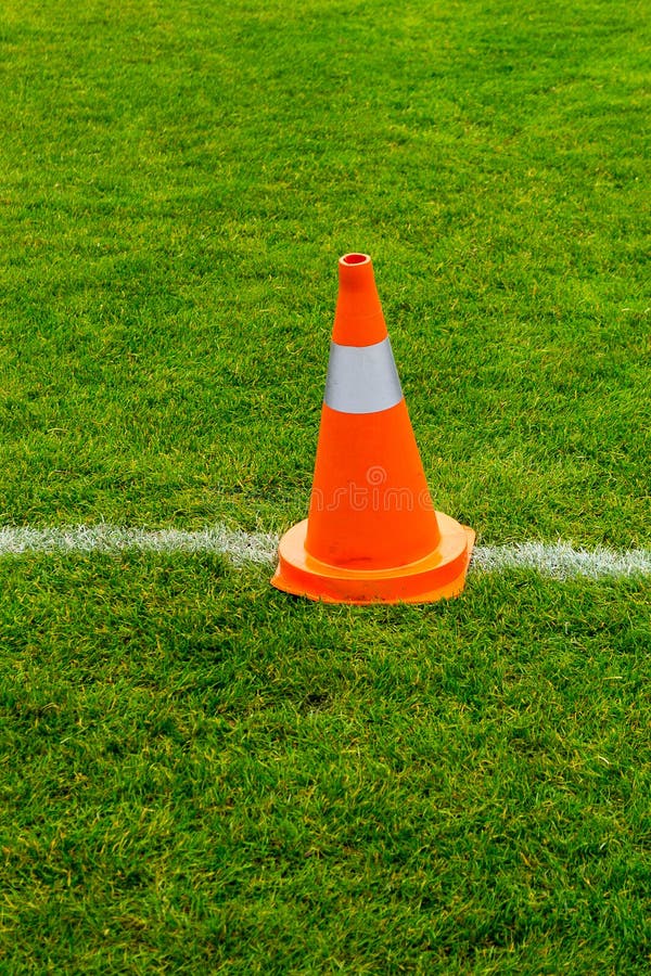 Orange cone on grass field stock image. Image of pylon 35131537