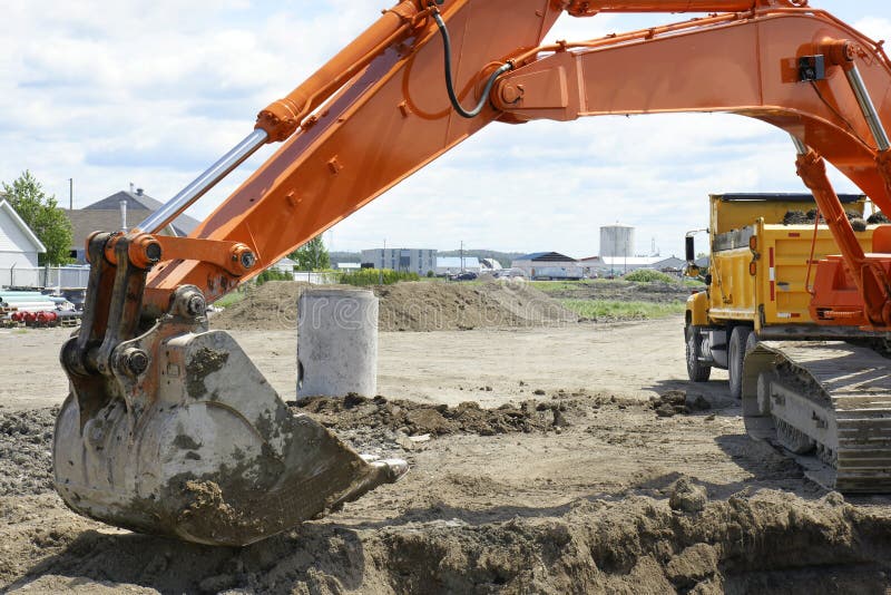 Orange digger and yellow dump truck stock photo Orange digger and yellow dump truck stock photo