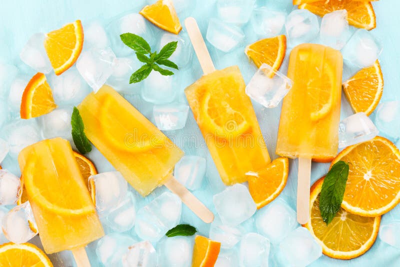 Orange Eislutscher- und Eiswürfel der Frucht und Scheiben der Orange auf Blauem lizenzfreie stockfotos Orange Eislutscher- und Eiswürfel der Frucht und Scheiben der Orange auf Blauem lizenzfreie stockfotos