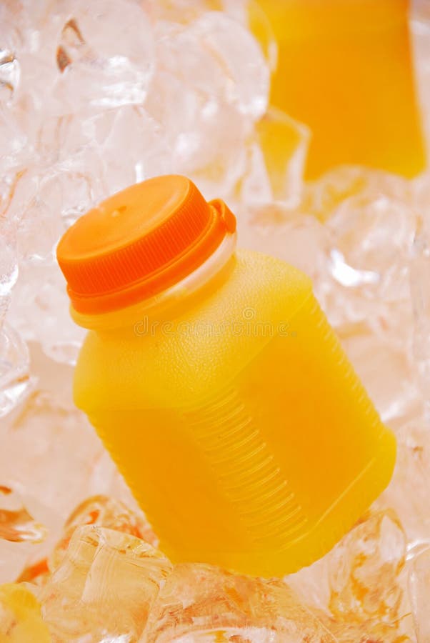 Orange fruktsaft i plast- flaska på iskuber arkivfoto Orange fruktsaft i plast- flaska på iskuber arkivfoto