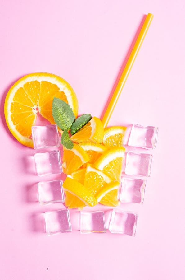 Orange juice cup made of ice cube on pink background