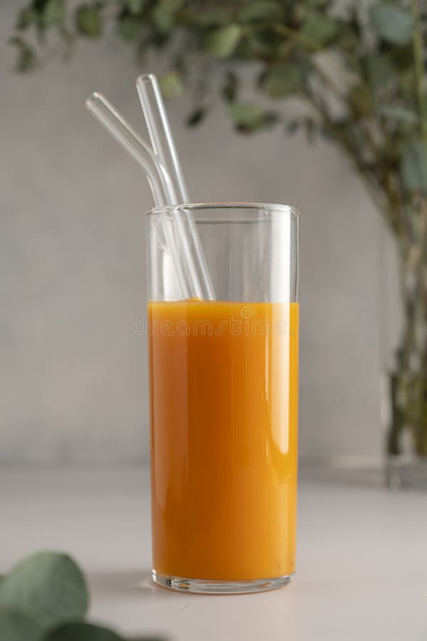 Orange Juice Glass with Reusable Glass Straws, on Bright Background