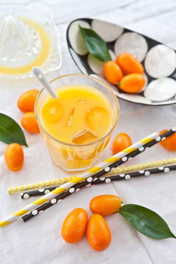 Orange juice and kumquats stock image. Image of straws 30320037