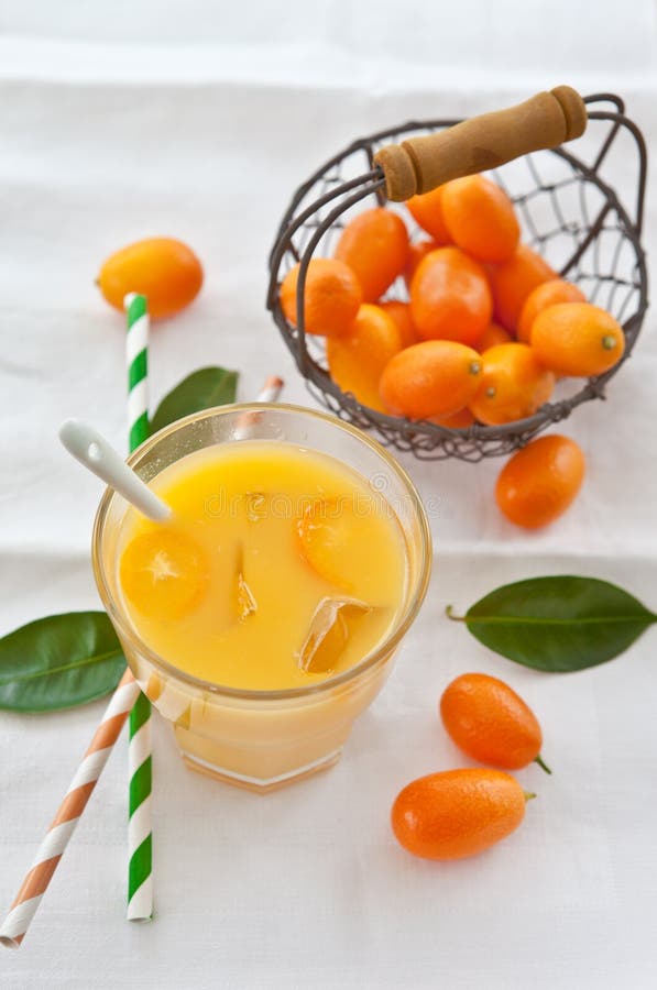Orange juice and kumquats stock image. Image of straws 30320037