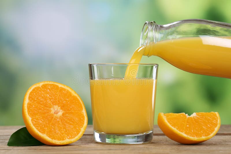 Fresh orange juice pouring into a glass in summer