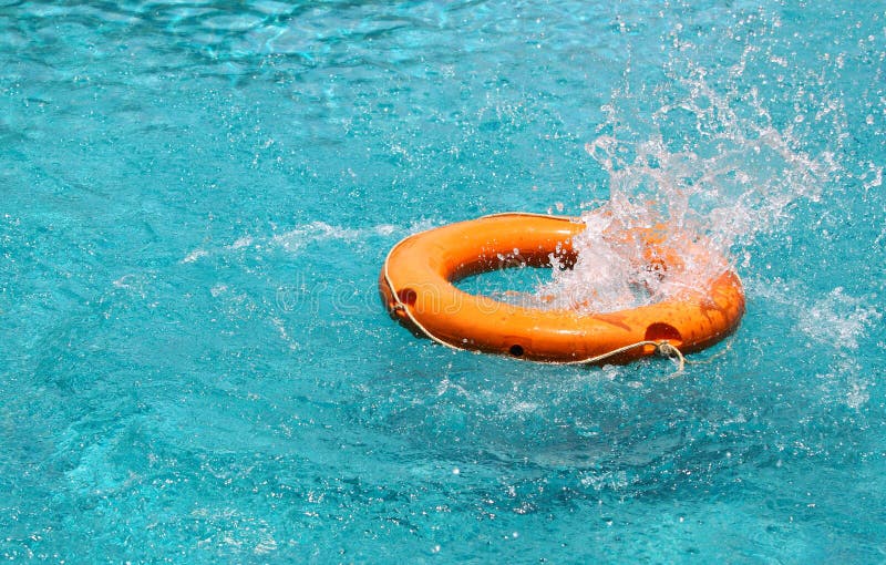 Orange life buoy splash water in the blue swimming pool