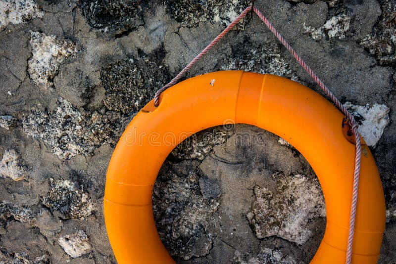 Orange Lifebuoy on vintage concrete wall stock photo Orange Lifebuoy on vintage concrete wall stock photo