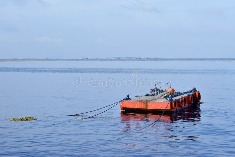 Orange malte Metalllastkahn verankert entlang Ozeanbucht lizenzfreie stockfotografie Orange malte Metalllastkahn verankert entlang Ozeanbucht lizenzfreie stockfotografie