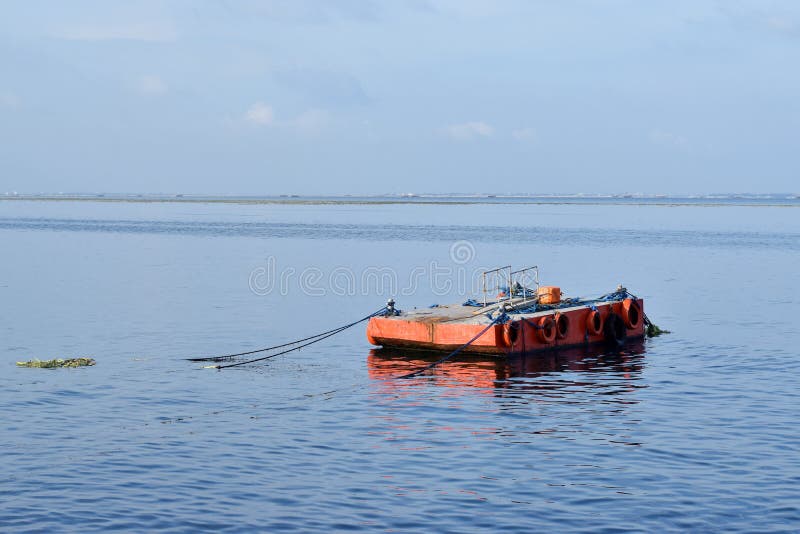 Orange malte Metalllastkahn verankert entlang Ozeanbucht lizenzfreie stockfotos Orange malte Metalllastkahn verankert entlang Ozeanbucht lizenzfreie stockfotos