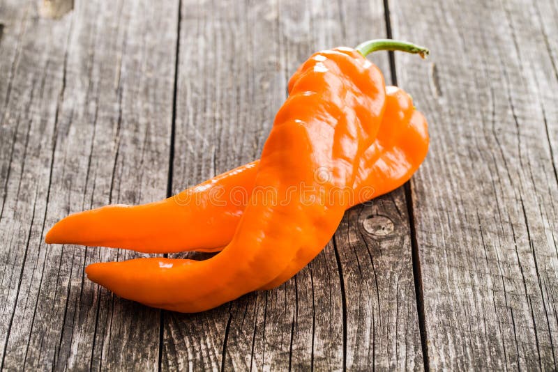 Orange pepper vegetable on old wooden table. Orange pepper vegetable on old wooden table.