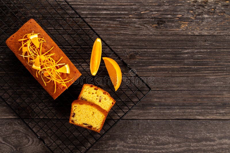 Orange pound cake on a cooling rack on dark vintage wood background, Flat lay. Copy space royalty free stock image Orange pound cake on a cooling rack on dark vintage wood background, Flat lay. Copy space royalty free stock image