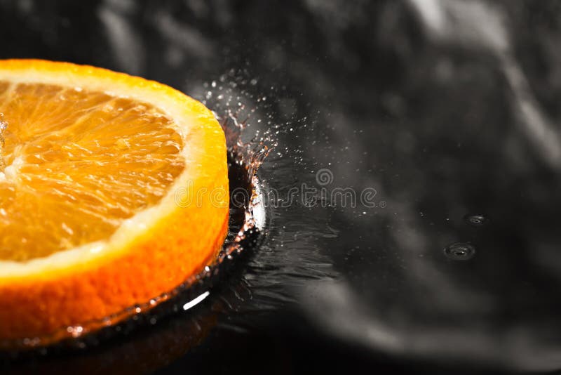 An Orange Ring with Splashes of Water, a Fruit with Splashes Stock