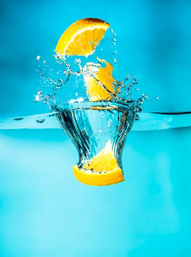 Orange slices falling into the blue water close-up, macro, splash water, bubbles. Bright photo. royalty free stock images Orange slices falling into the blue water close-up, macro, splash water, bubbles. Bright photo. royalty free stock images