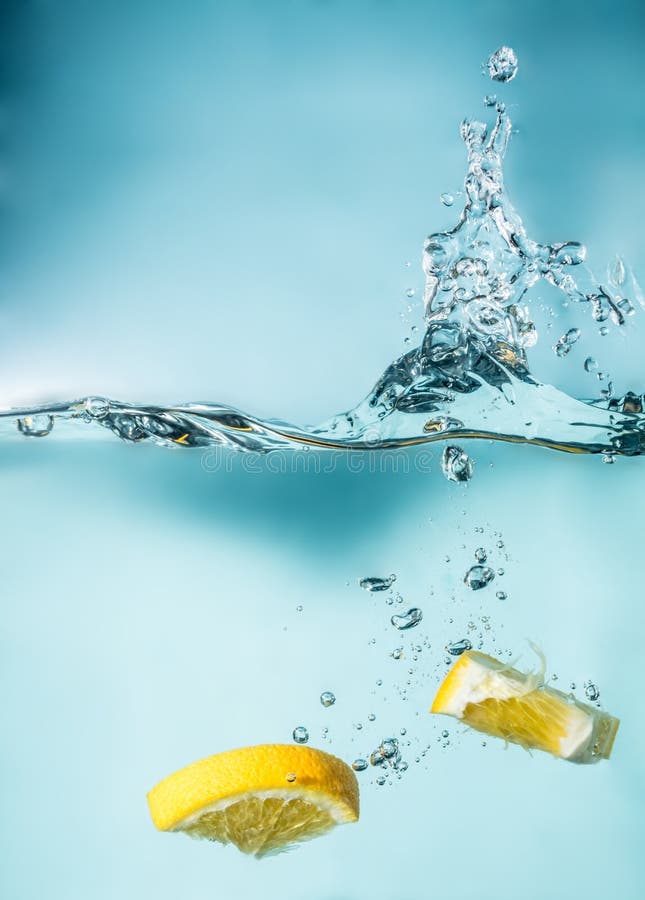 Orange slices falling into the blue water close-up, macro, splash water, bubbles, blue background stock images Orange slices falling into the blue water close-up, macro, splash water, bubbles, blue background stock images