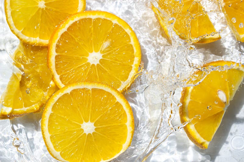 Orange Slices in Water on a White Background. Orange Slices Fall into