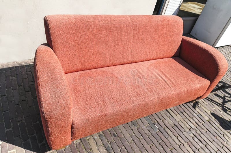 Orange Sofa gesetztes im Freien auf der Straße stockfotos Orange Sofa gesetztes im Freien auf der Straße stockfotos