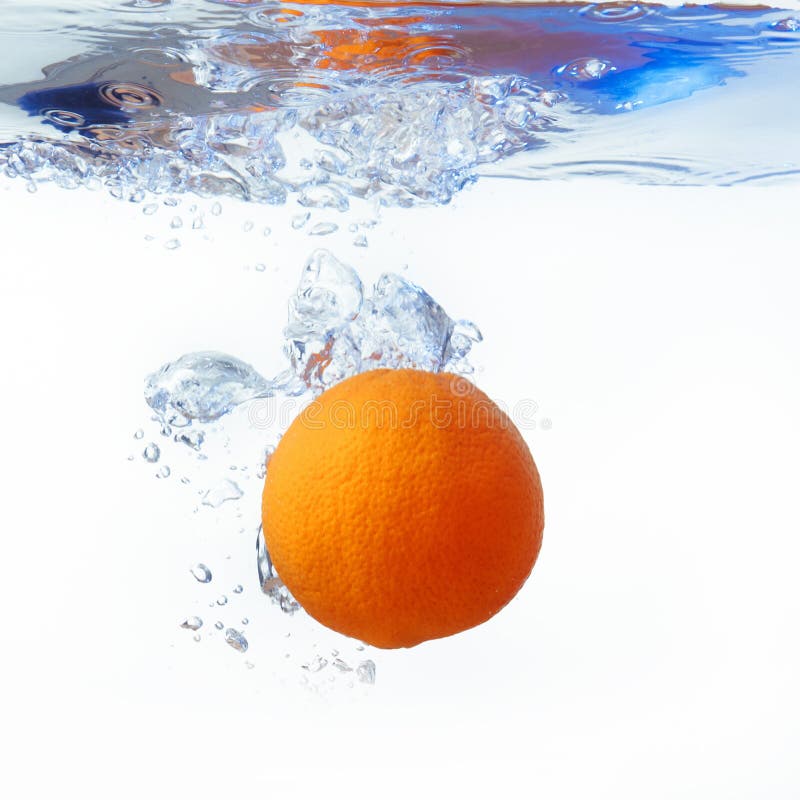 Orange in spray of water with splash on white background
