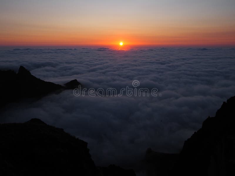 Orange sunrise ovanför molnen i bergen Pico del Arieiro Madeira Portugal. Solen stiger över himlen arkivfoto