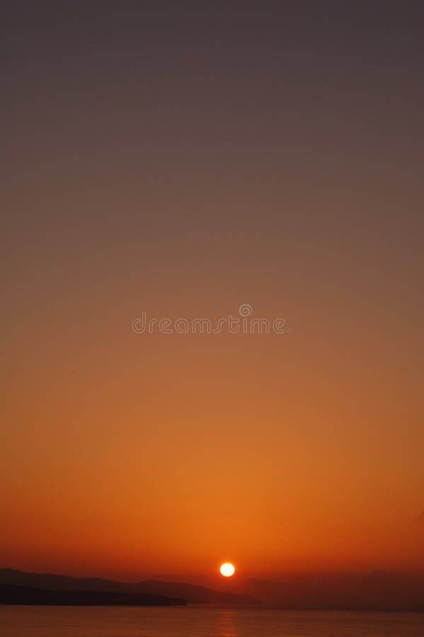 Orange sunset with copy space: sun sinking behind the Fuerteventura island into the ocean.