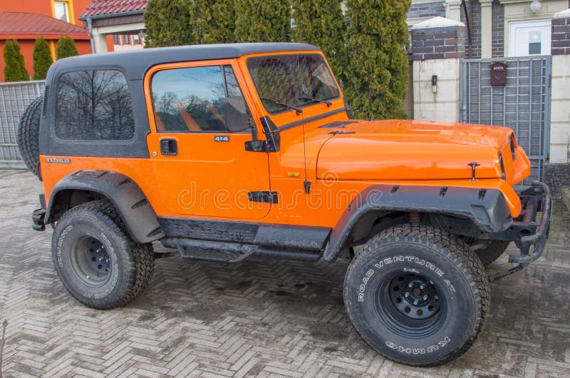 Orange Two Door Jeep Wrangler SUV with Gray Roof and Square Headlights  Standing on Gray Sidewalk Tiles in Front of House Editorial Image - Image  of kaliningrad, headlights: 186854095