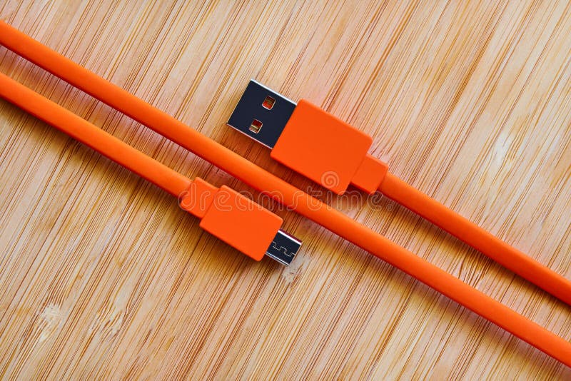 Orange USB Cable for Gadgets on a Wooden Background Stock Photo Image