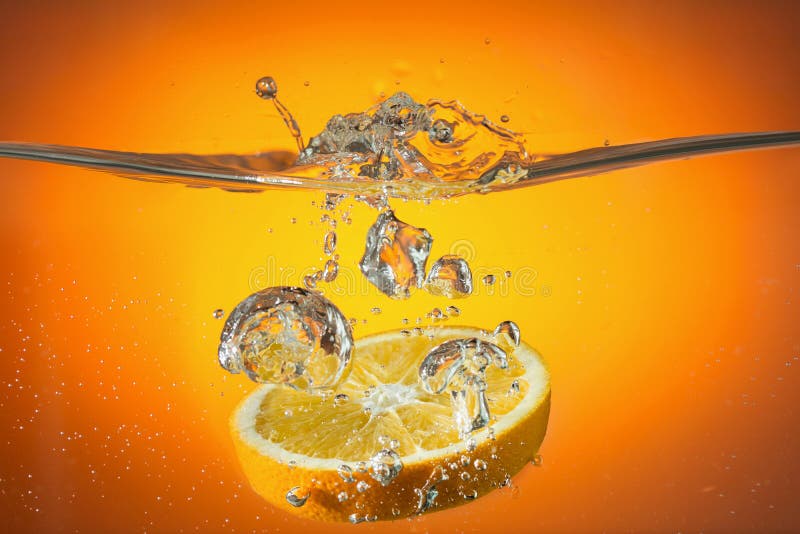 Orange slice dropped in water. Orange slice dropped in water