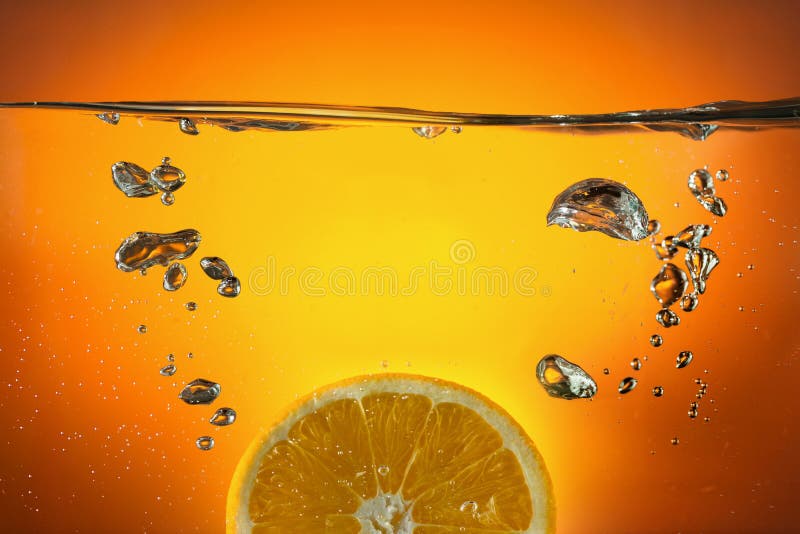 Orange slice dropped in water. Orange slice dropped in water