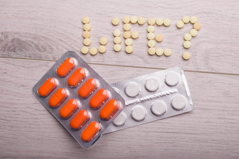 Orange and White Pills in the Package are on the Table Stock Image