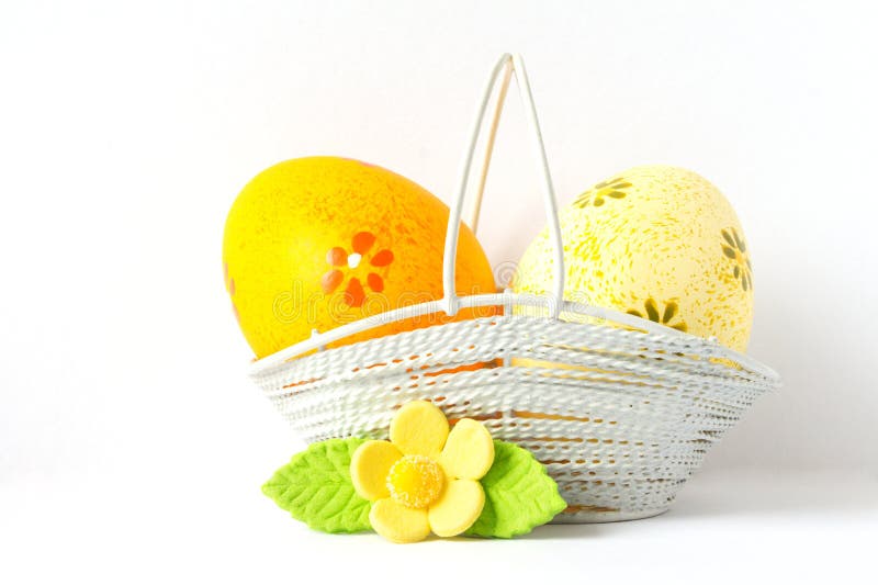 Orange and Yellow Easter Eggs in a Basket with Yellow Flower Stock