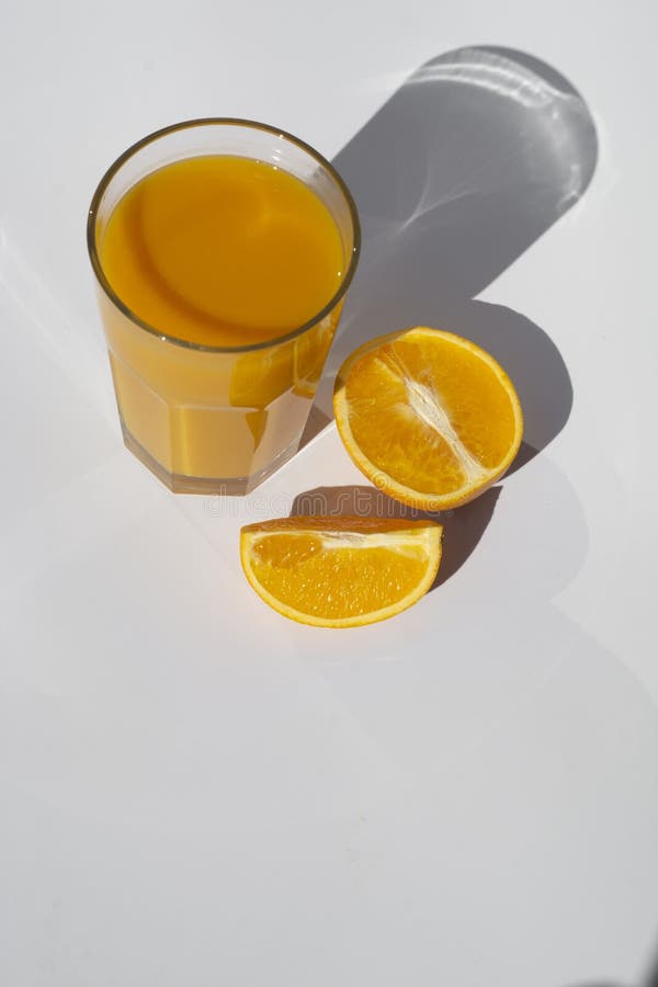 Orangensaftglas mit in Scheiben geschnittenen orangefarbenen Schatten, die auf weißem Grund isoliert sind stockbild Orangensaftglas mit in Scheiben geschnittenen orangefarbenen Schatten, die auf weißem Grund isoliert sind stockbild