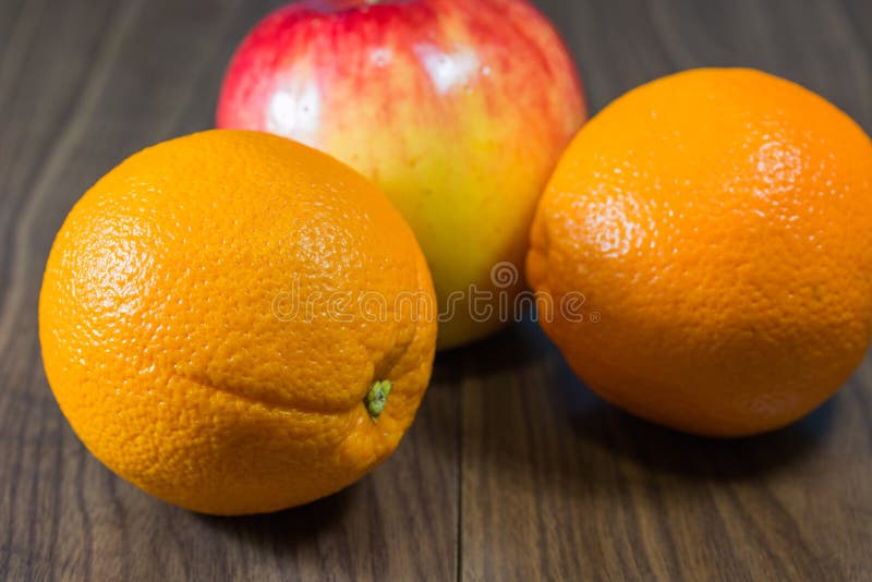 Oranges and apples pile on wooden floor. Oranges and apples pile on wooden floor.