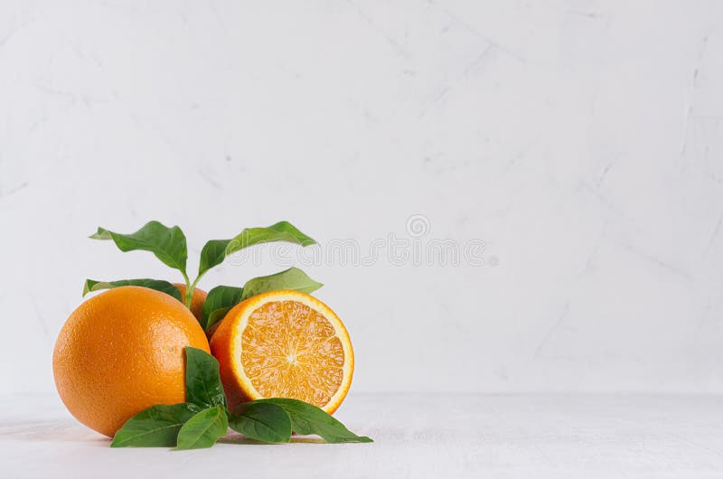 Oranges lumineuses de groupe avec la feuille et le morceau verts frais sur l'intérieur moderne blanc de lumière molle image stock Oranges lumineuses de groupe avec la feuille et le morceau verts frais sur l'intérieur moderne blanc de lumière molle image stock