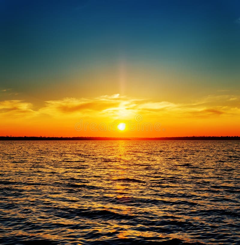 Oranje zonsondergang boven de rivier royalty-vrije stock afbeelding