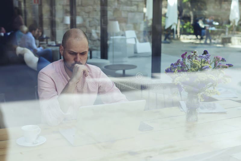 Ordenador portátil abierto del frente del hombre de negocios que se sienta o del empresario en interior moderno de la cafetería e fotos de archivo libres de regalías Ordenador portátil abierto del frente del hombre de negocios que se sienta o del empresario en interior moderno de la cafetería e fotos de archivo libres de regalías