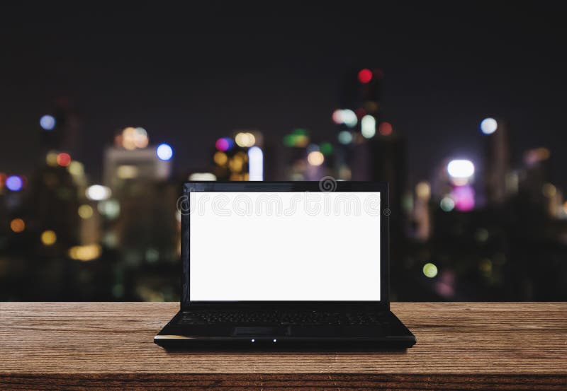 Ordenador portátil del ordenador en el escritorio de madera con las luces de Bokeh de la ciudad en el fondo de la noche Pantalla imágenes de archivo libres de regalías Ordenador portátil del ordenador en el escritorio de madera con las luces de Bokeh de la ciudad en el fondo de la noche Pantalla imágenes de archivo libres de regalías