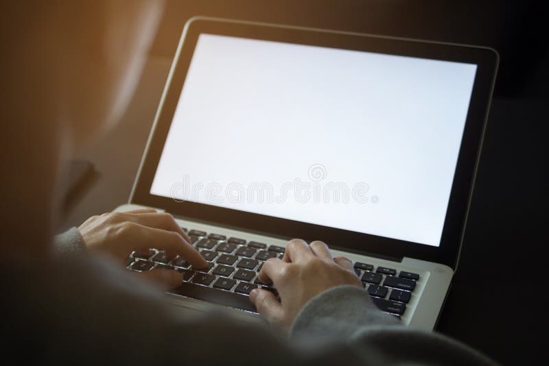 Ordenador portátil que usa femenino con la pantalla en blanco en el escritorio en hogar imagen de archivo Ordenador portátil que usa femenino con la pantalla en blanco en el escritorio en hogar imagen de archivo