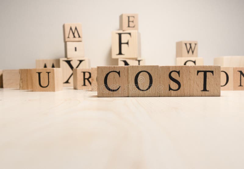 The word Cost is from wooden cubes. Background from wooden letters. The word Cost is from wooden cubes. Background from wooden letters