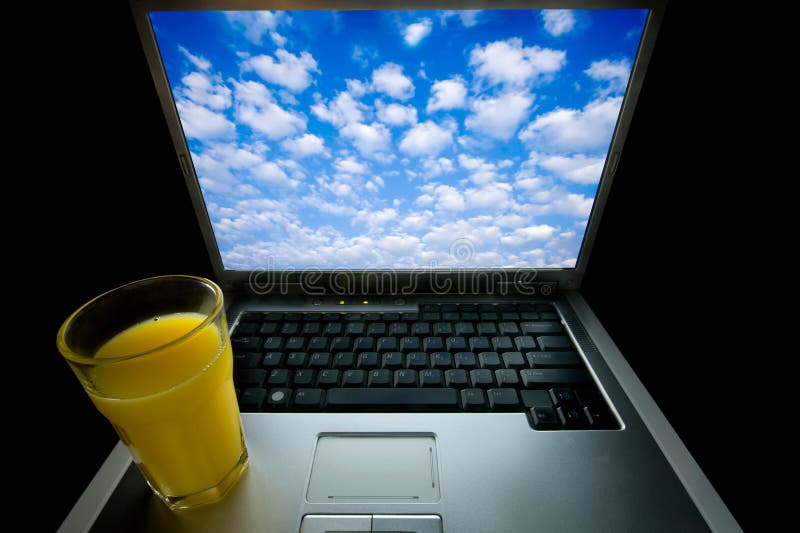 Ordinateur portable et jus d'orange photo stock Ordinateur portable et jus d'orange photo stock