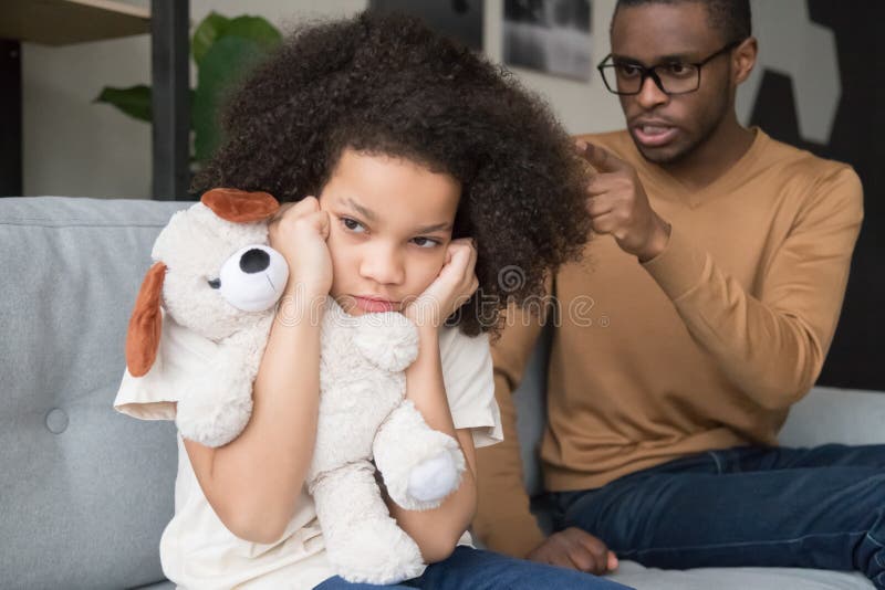 Stubborn naughty african preschool child girl closing ears ignoring angry strict black dad scolding yelling reprimand kid daughter for rude disrespect mistake, parents children family fight concept. Stubborn naughty african preschool child girl closing ears ignoring angry strict black dad scolding yelling reprimand kid daughter for rude disrespect mistake, parents children family fight concept