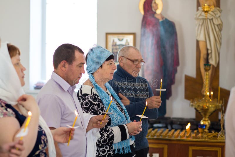 Orenburg, russo Federation-2 Aprel 2019 os povos guardam velas durante o ritual do batismo na igreja ortodoxa imagem de stock royalty free Orenburg, russo Federation-2 Aprel 2019 os povos guardam velas durante o ritual do batismo na igreja ortodoxa imagem de stock royalty free
