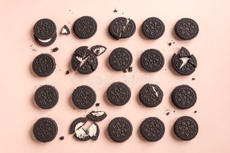 Tasty chocolate cookies with cream on color background, flat lay