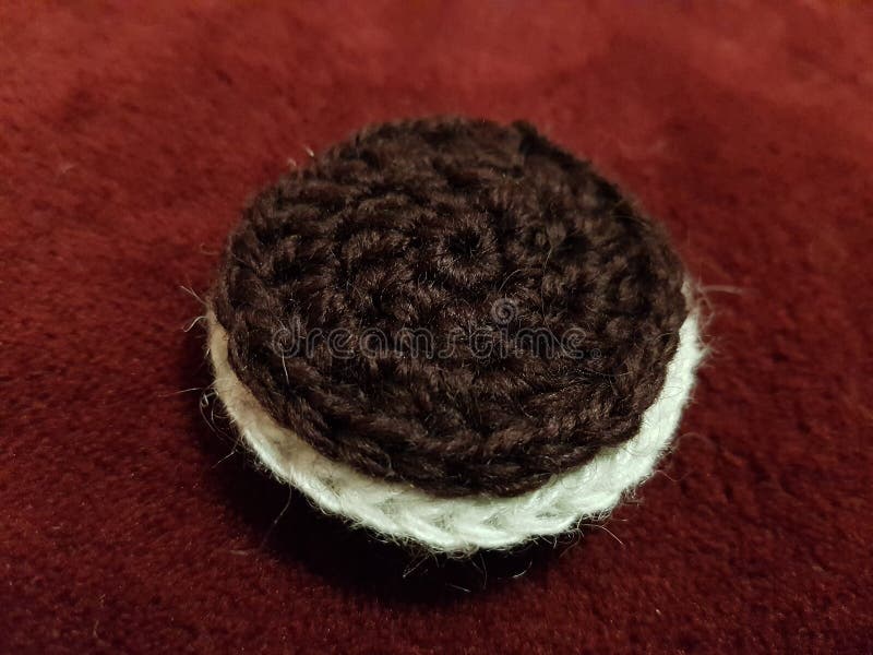 Oreo-kakor som är stickade från ull mot ett sängtäcke arkivbild Oreo-kakor som är stickade från ull mot ett sängtäcke arkivbild