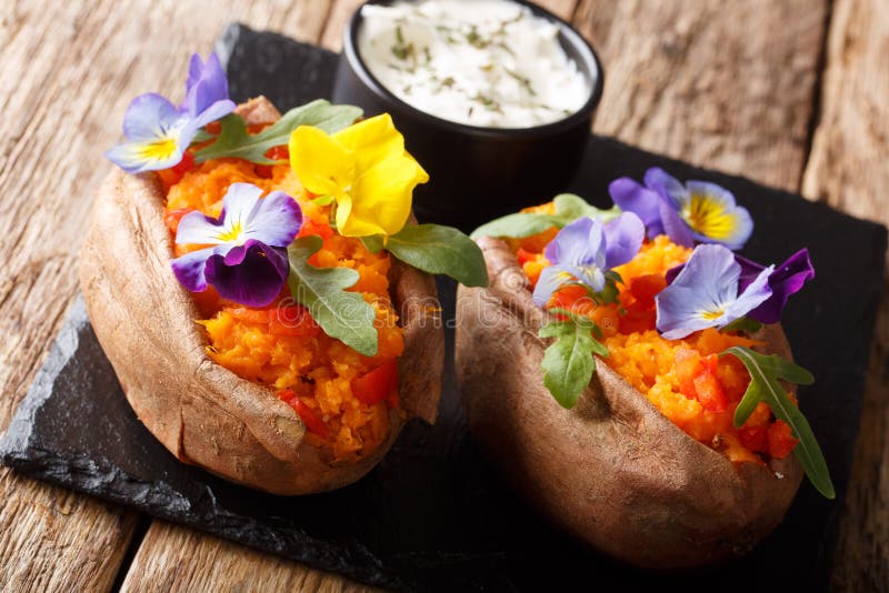 Organic Baked Sweet Potato with Edible Flowers is Served with Sauce on